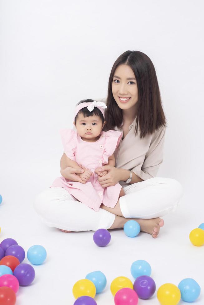 mère asiatique et adorable petite fille sont heureuses sur fond blanc photo