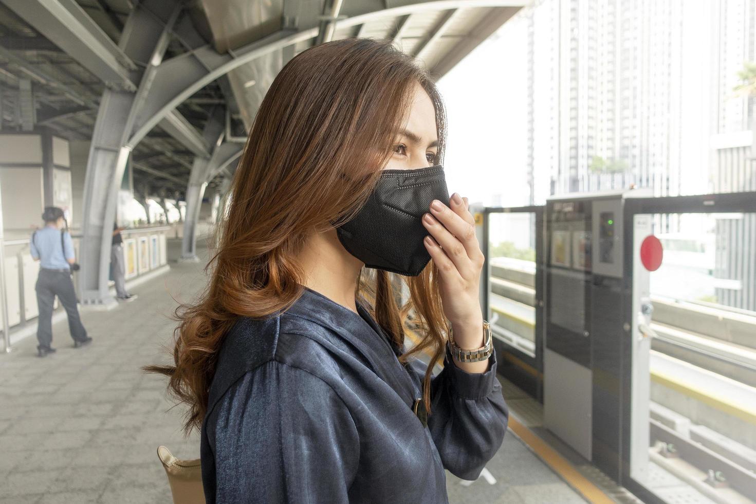 belle femme portant un masque anti-poussière protège la pollution de l'air et pm 2,5 sur la ville de la rue photo