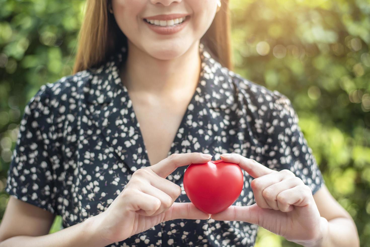 la main de la femme tient le coeur rouge, l'amour et le concept de soins de santé photo