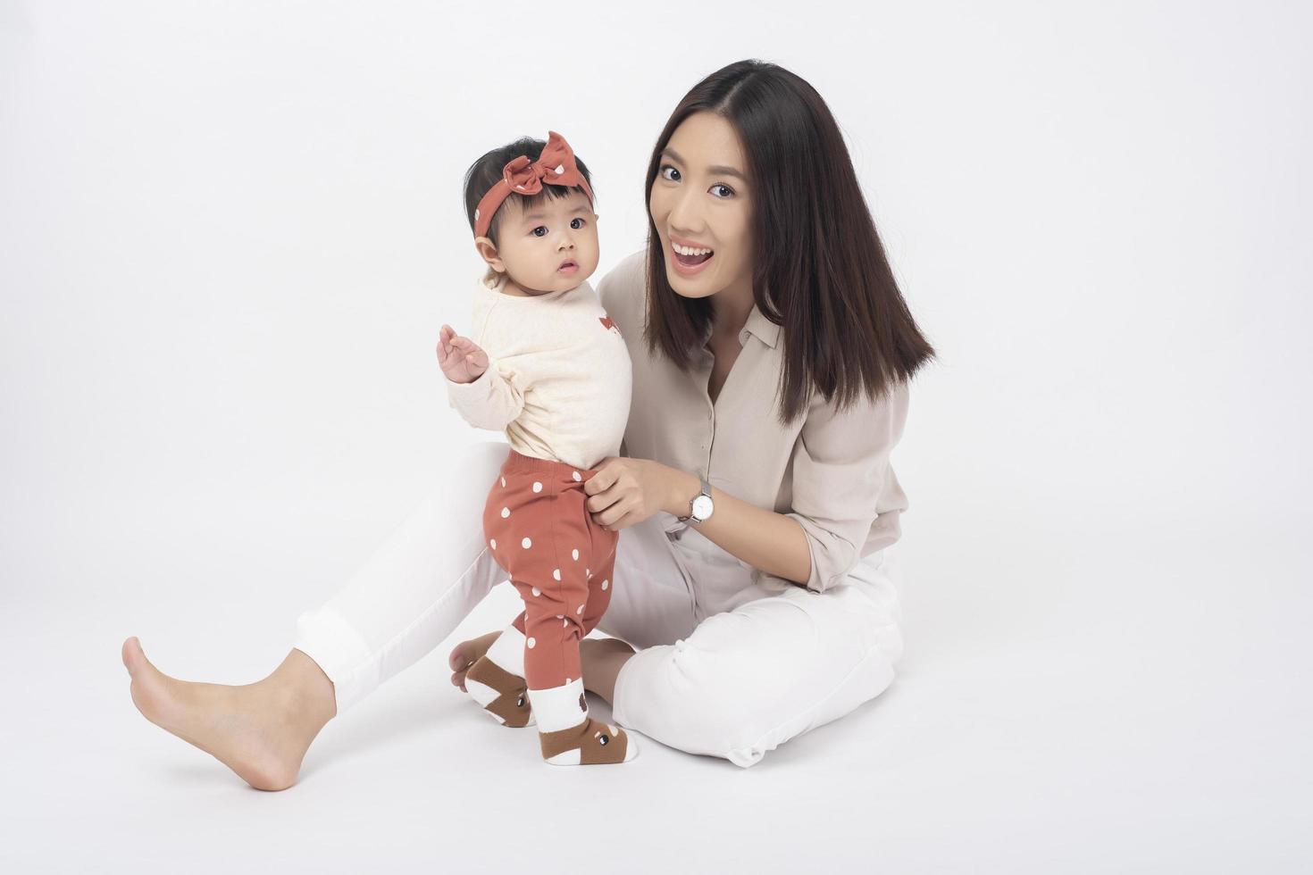 mère asiatique et adorable petite fille sont heureuses sur fond blanc photo