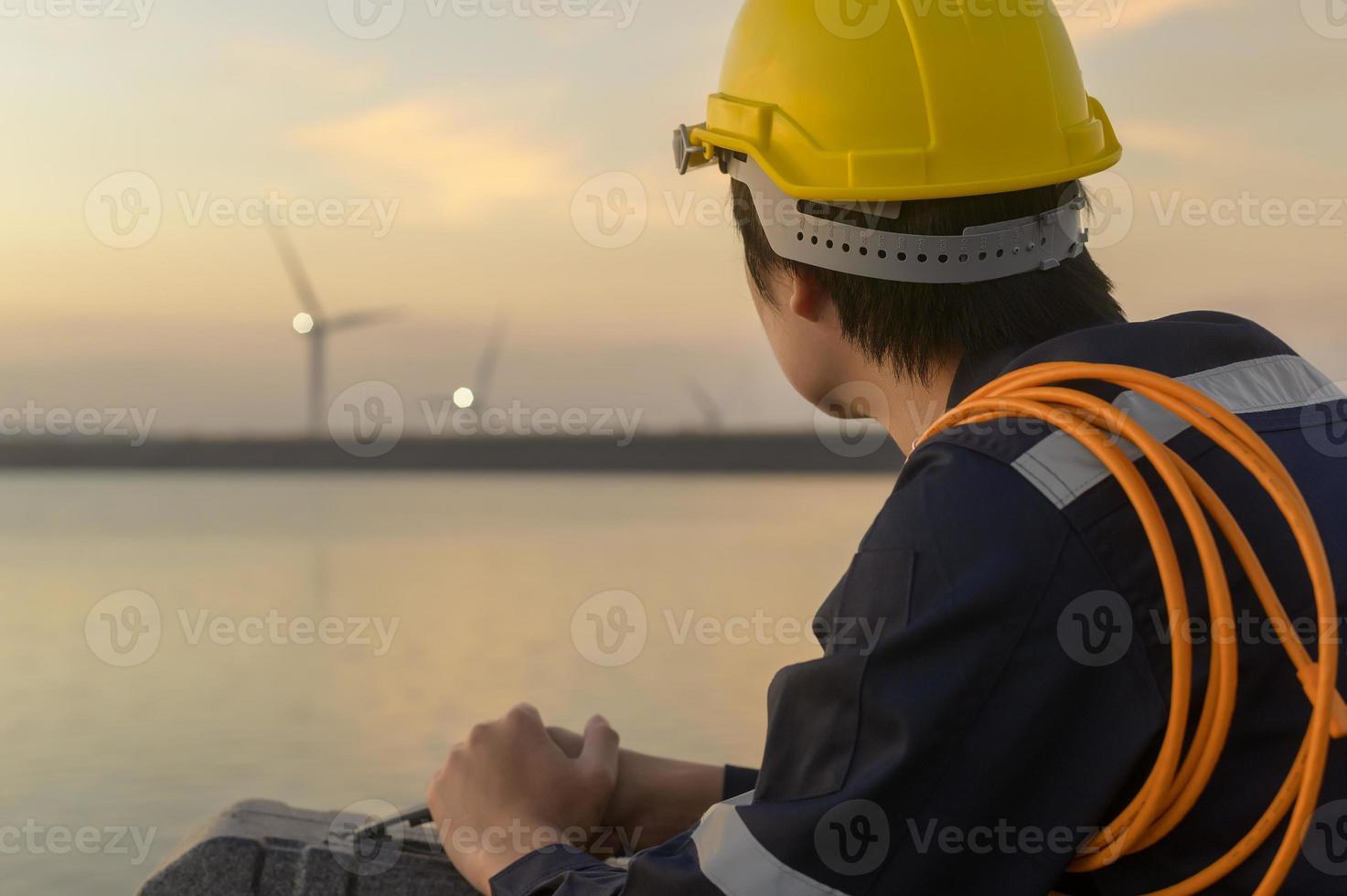 un ingénieur portant un casque de protection au coucher du soleil. photo