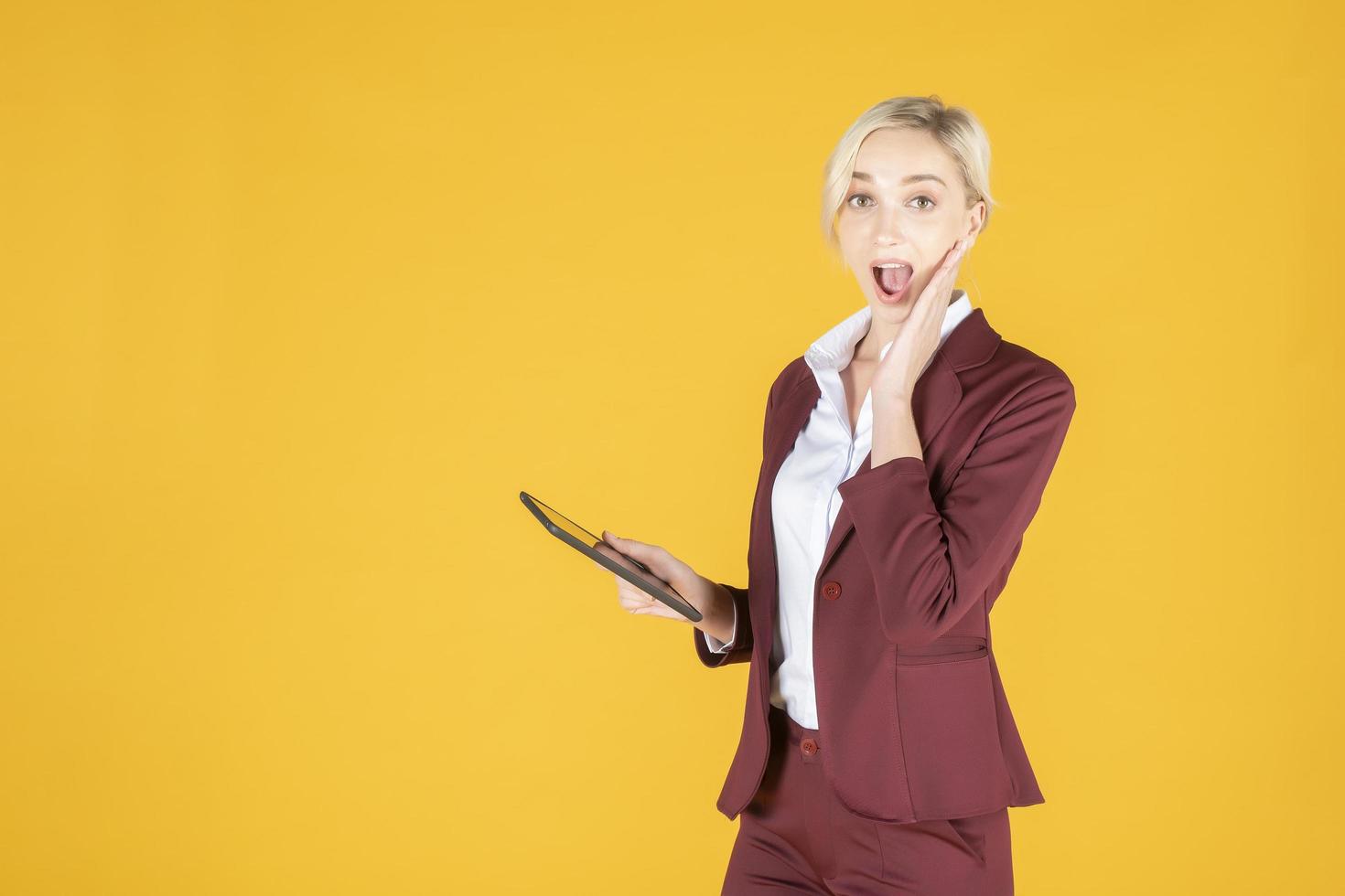 femme d'affaires est surprenante en studio fond jaune photo