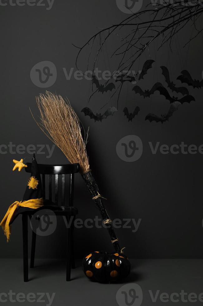 Halloween avec des chauves-souris noires sur un arbre avec une citrouille et un chapeau sur fond sombre photo