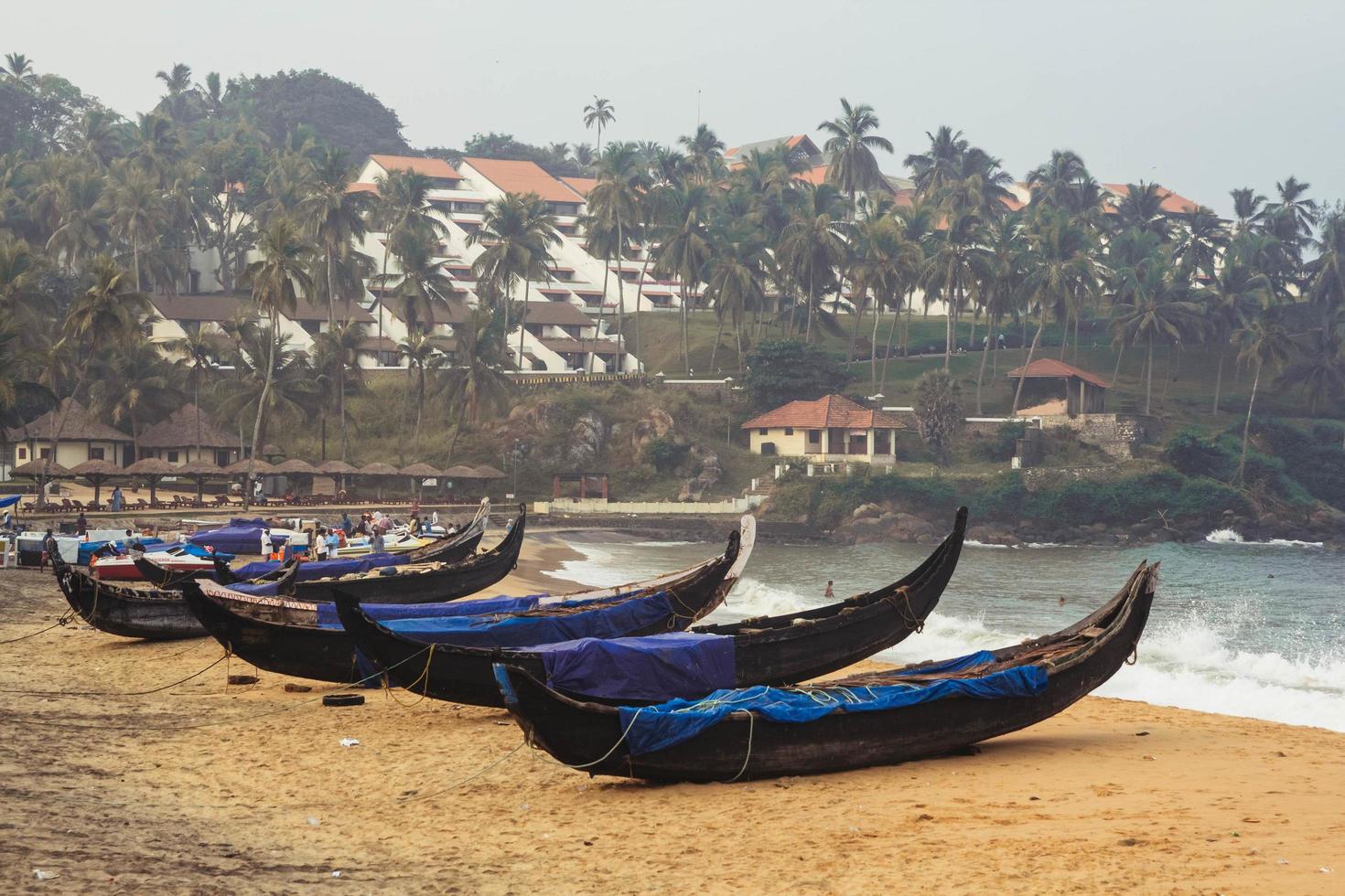 bateau de pêche sur la plage l'océan sur fond de palmiers à kovalam, kerala, inde. copie, espace vide pour le texte photo