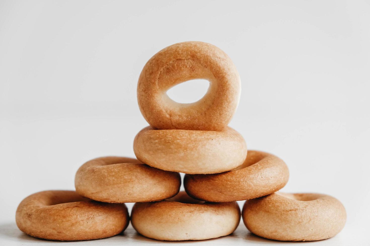 séchage ou mini bagels ronds en forme de pyramide sur fond de bois blanc. copie, espace vide pour le texte photo