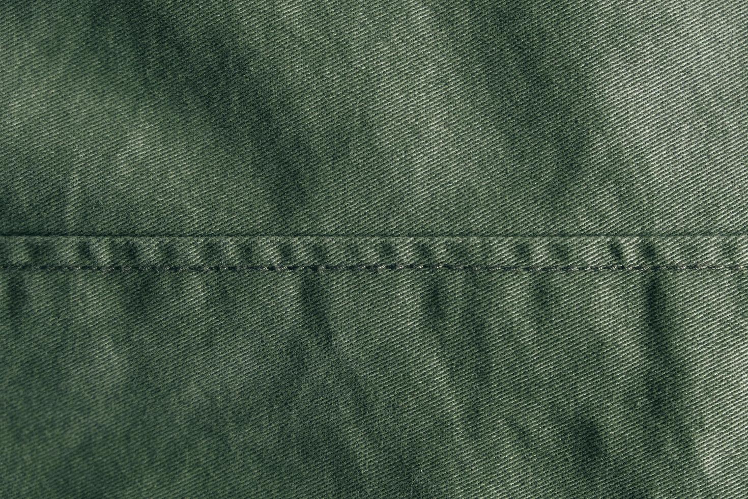 fond denim vert orné d'une couture. texture de couture en denim vert photo