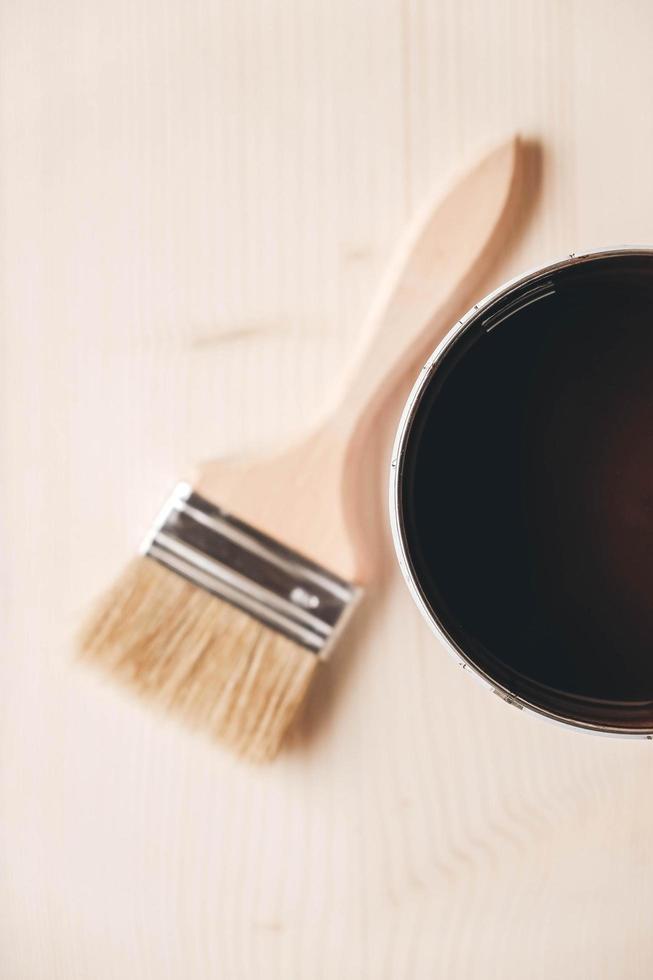 pinceau sur un pot avec de la peinture brune sur un fond en bois photo