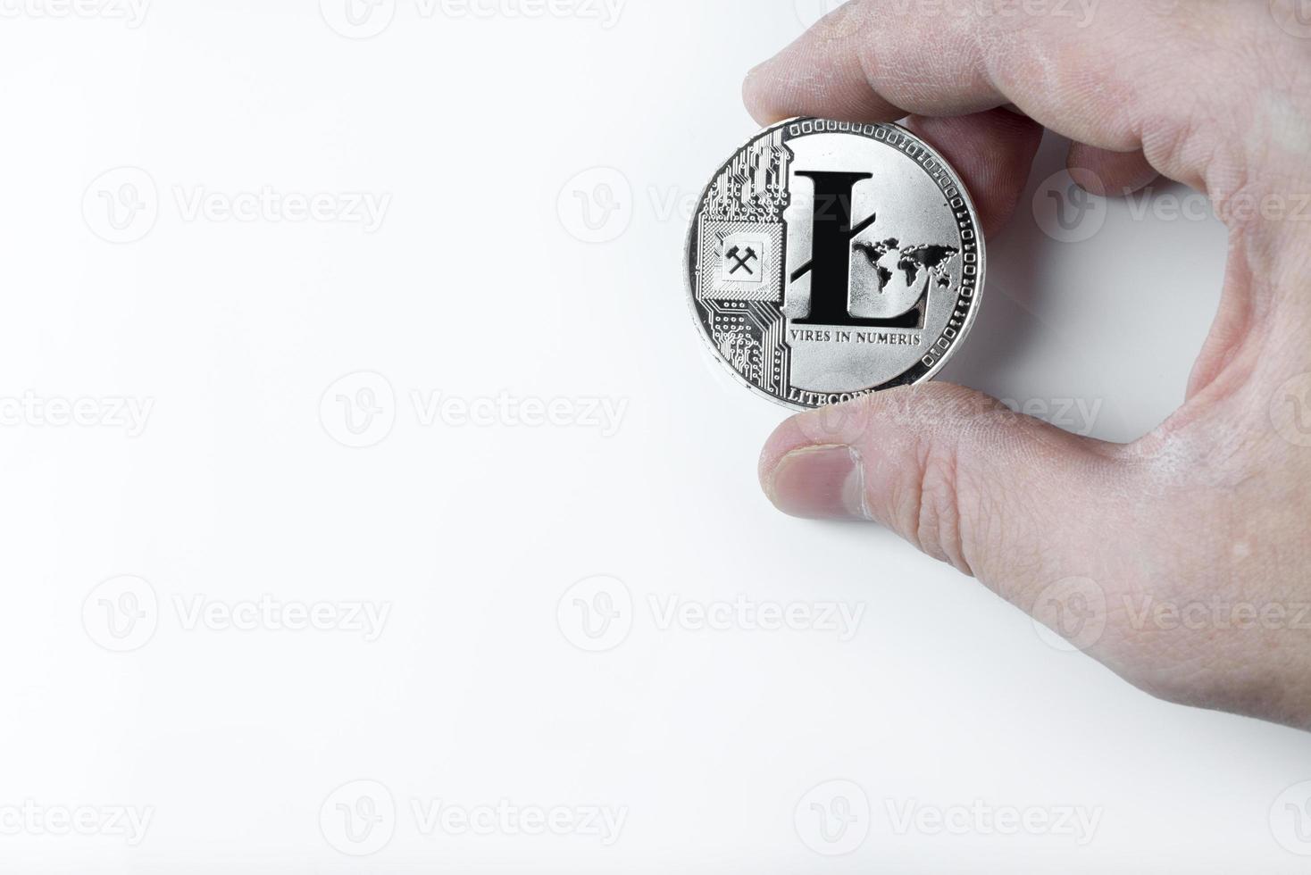 la main tient un litecoin sur un fond blanc. photo