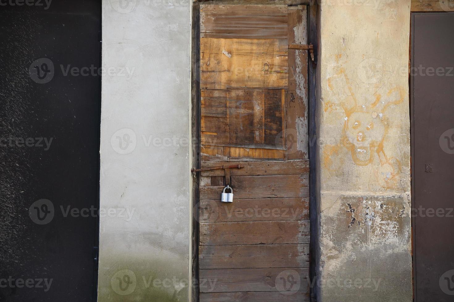 Vieille porte en bois verrouillée patinée avec cadenas photo