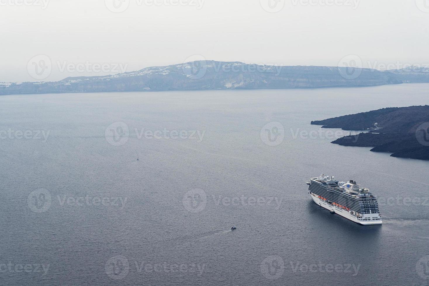 beau paysage avec vue sur la mer. bateau de croisière en mer près de nea kameni, une petite île grecque de la mer égée près de santorin. photo