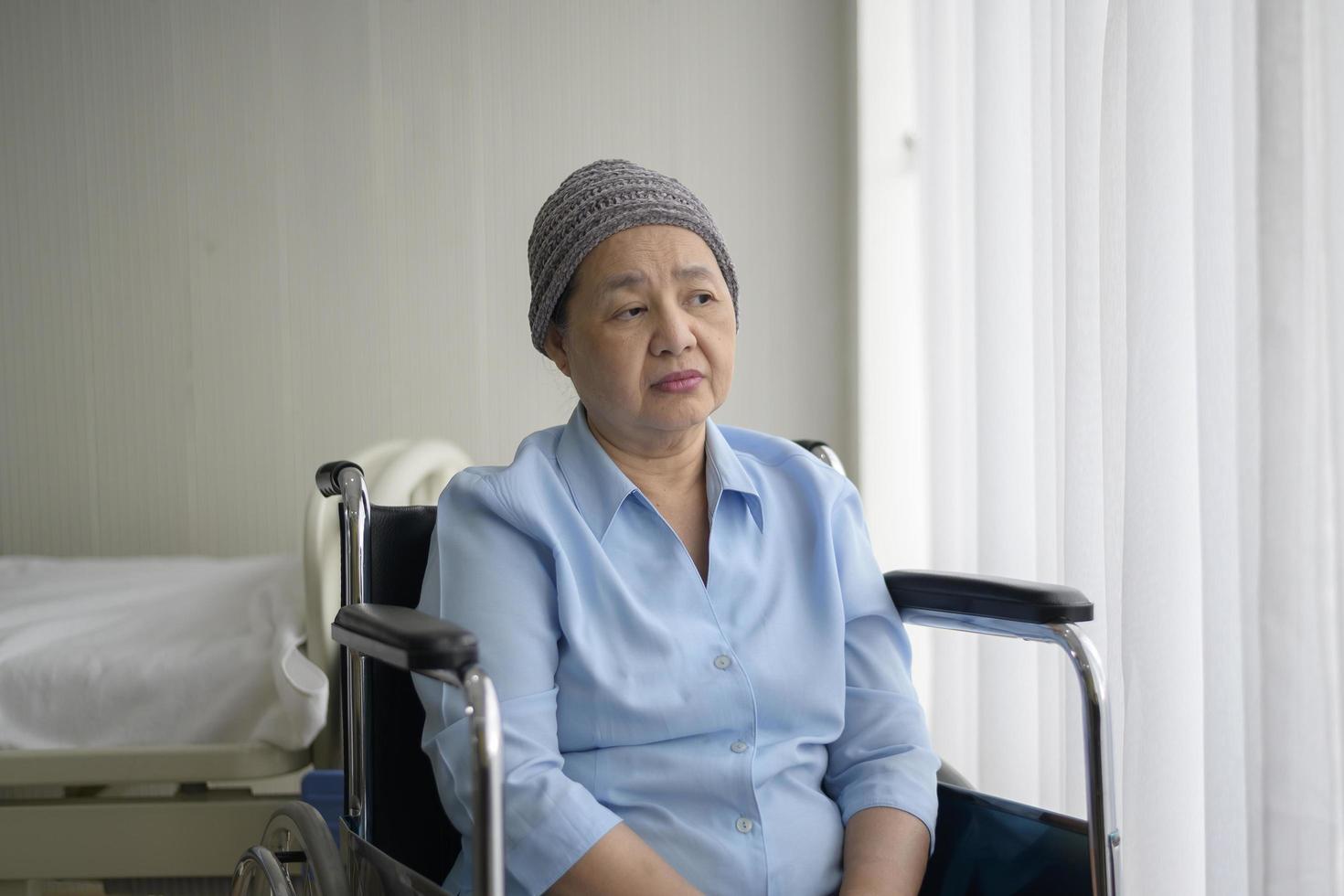 femme asiatique souffrant de cancer déprimée et désespérée portant un foulard à l'hôpital. photo