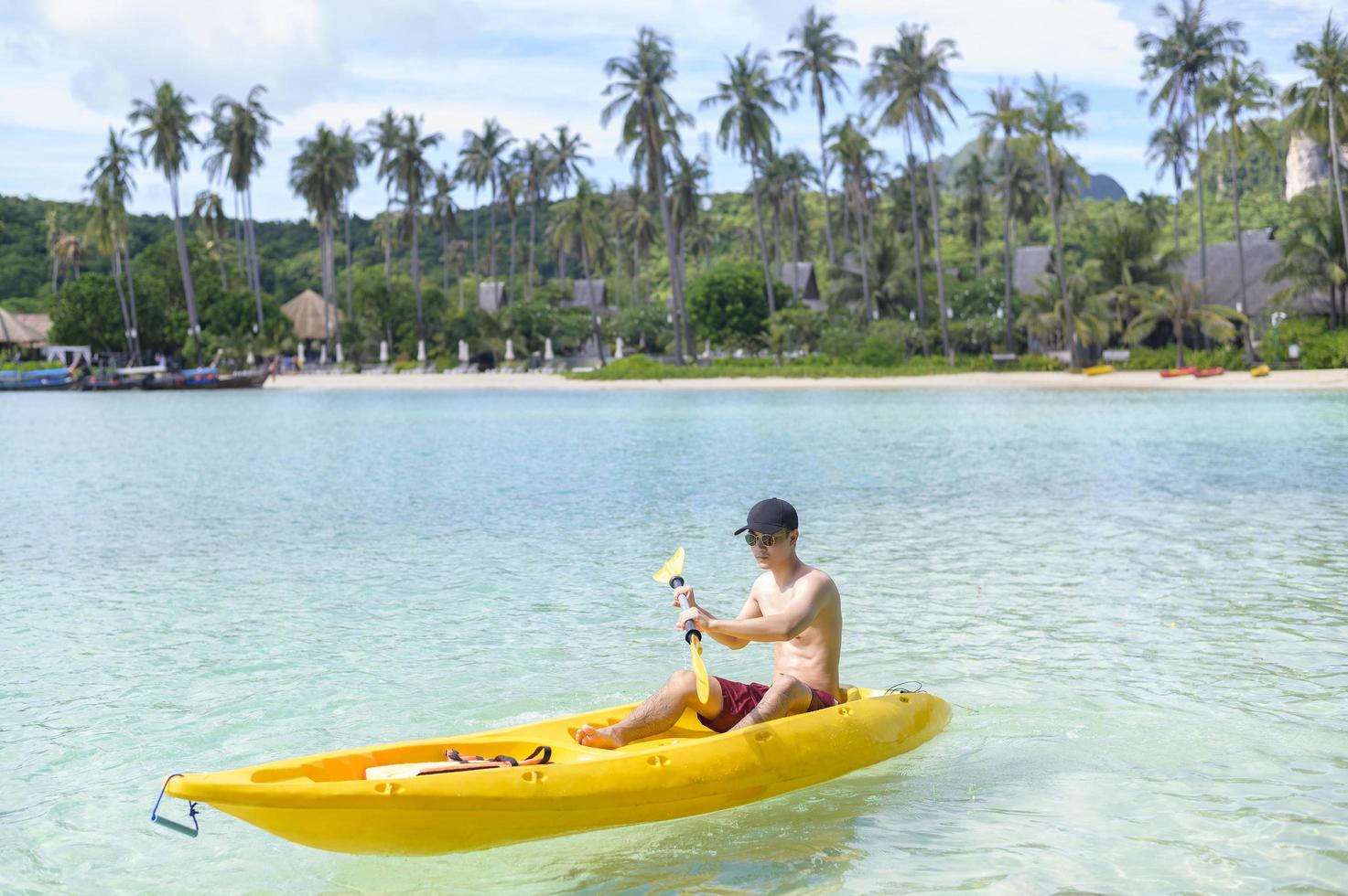 un jeune homme sportif faisant du kayak à l'océan par une journée ensoleillée photo