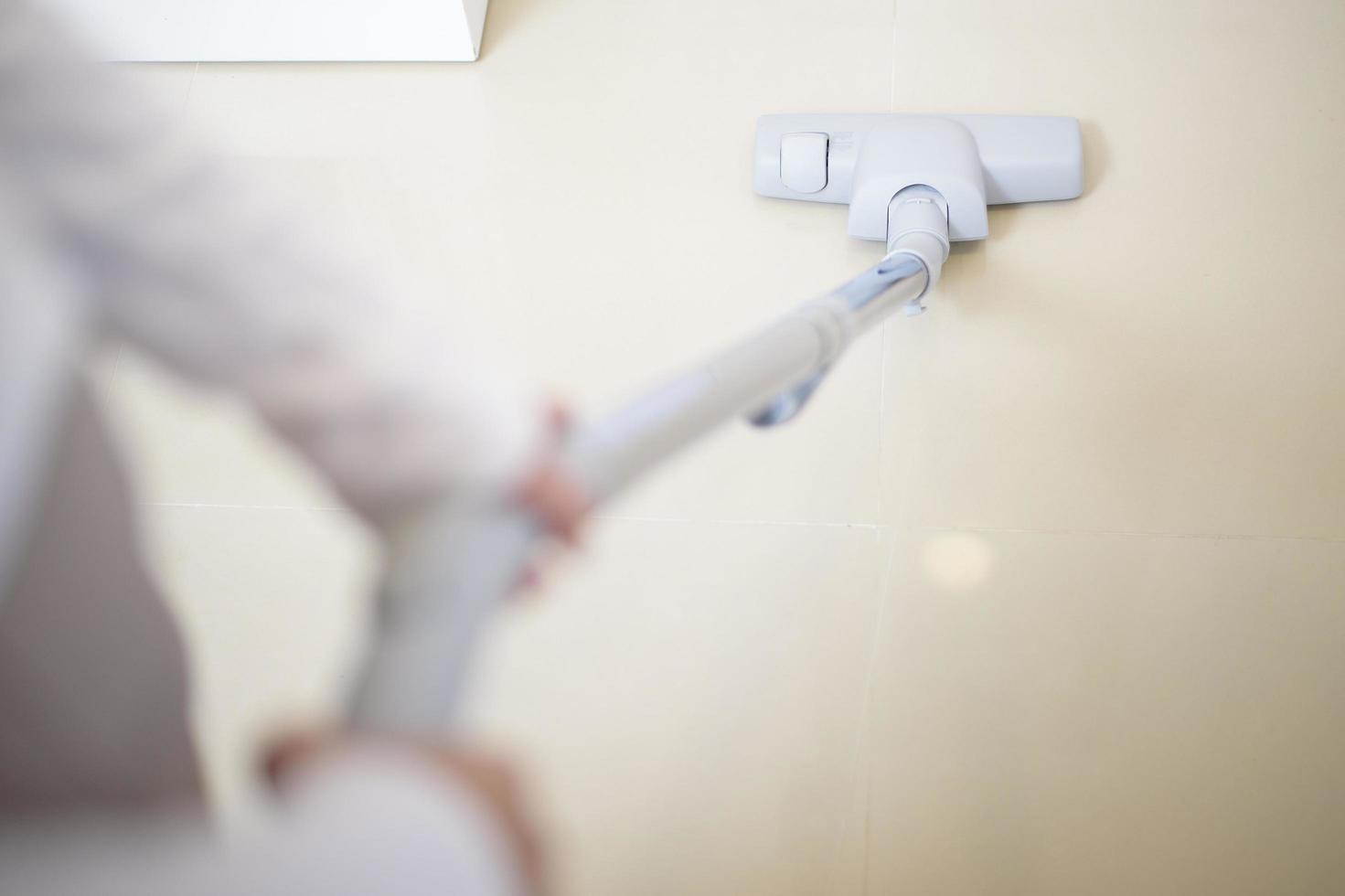 femme nettoie la maison avec une machine à vide photo