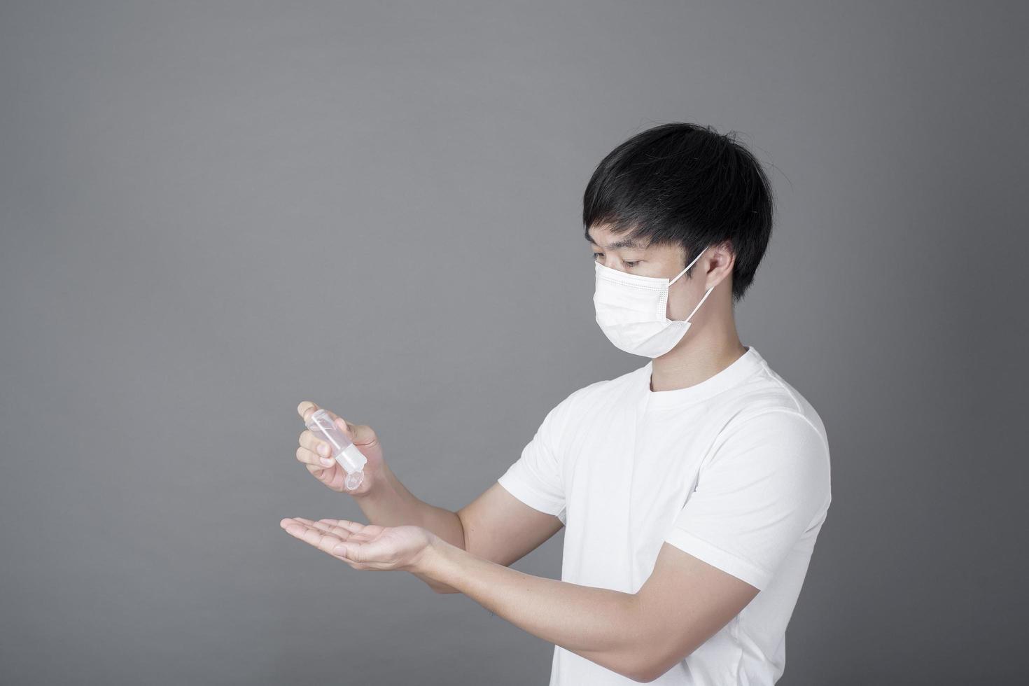 portrait d'homme se désinfectant les mains avec du gel d'alcool, concept de soins de santé photo