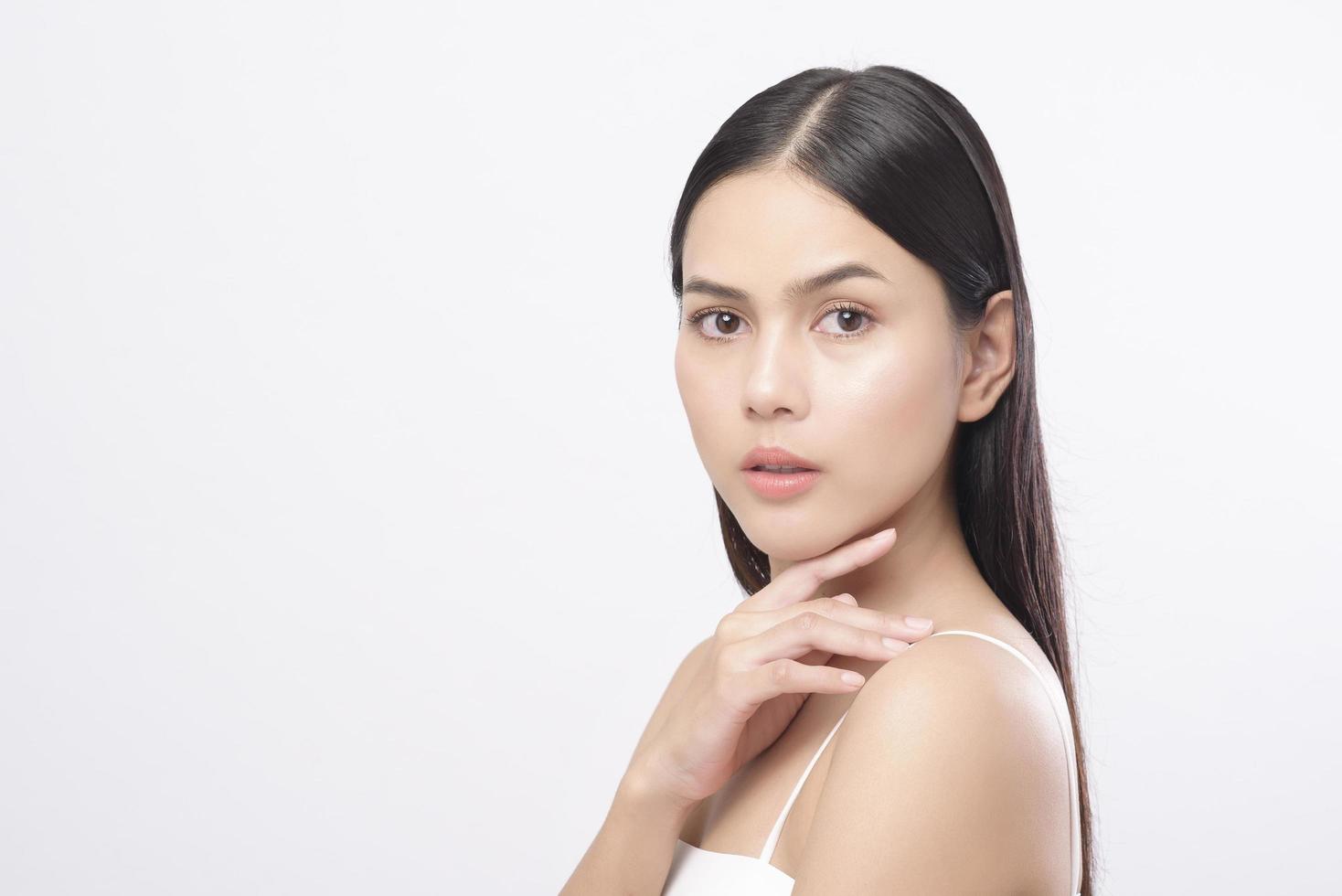 portrait de jeune belle femme avec une peau saine et lisse sur fond blanc, concept de soins de la peau photo