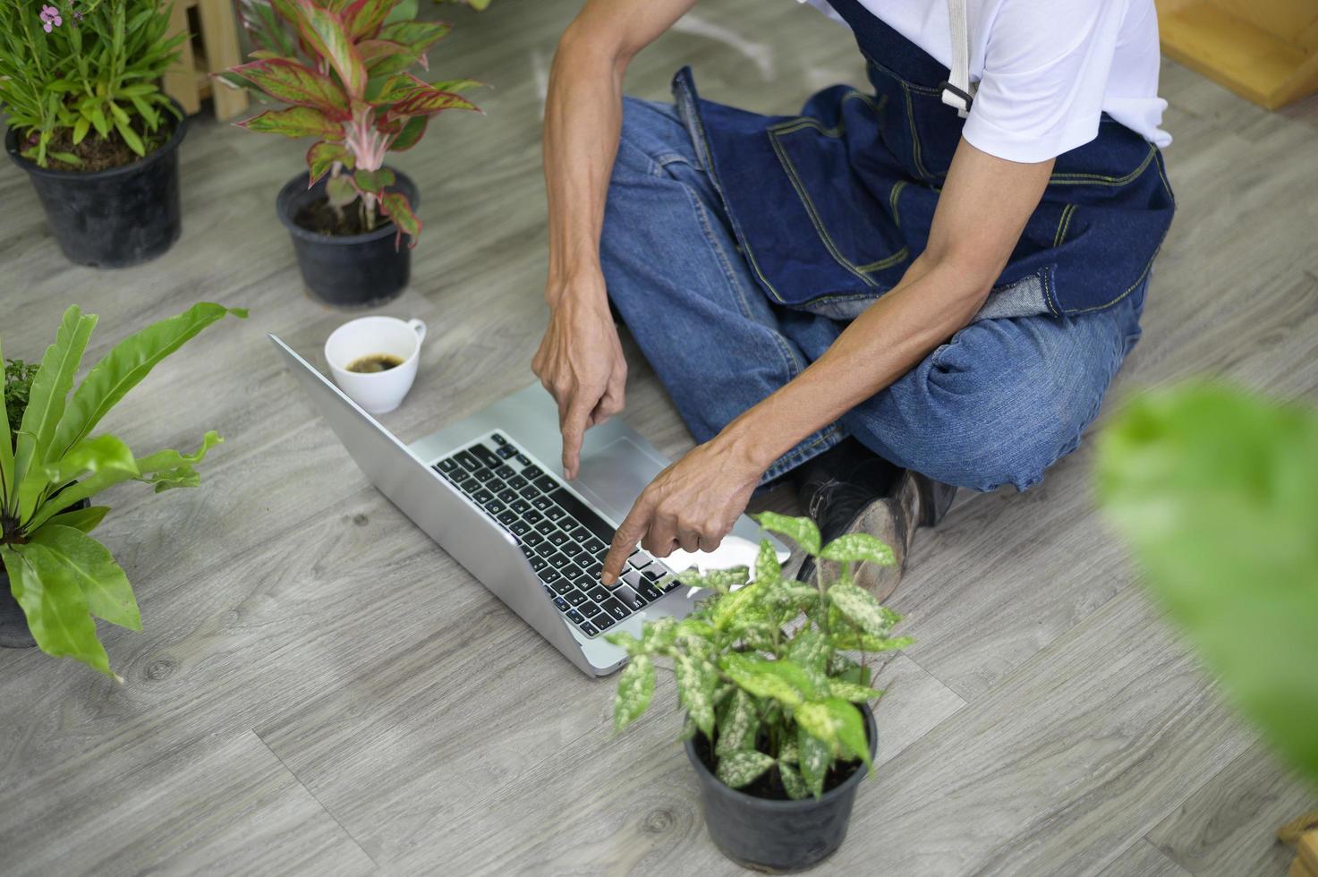 vue de dessus d'un homme retraité asiatique senior heureux avec un ordinateur portable se détend et profite d'activités de loisirs dans le jardin à la maison. photo