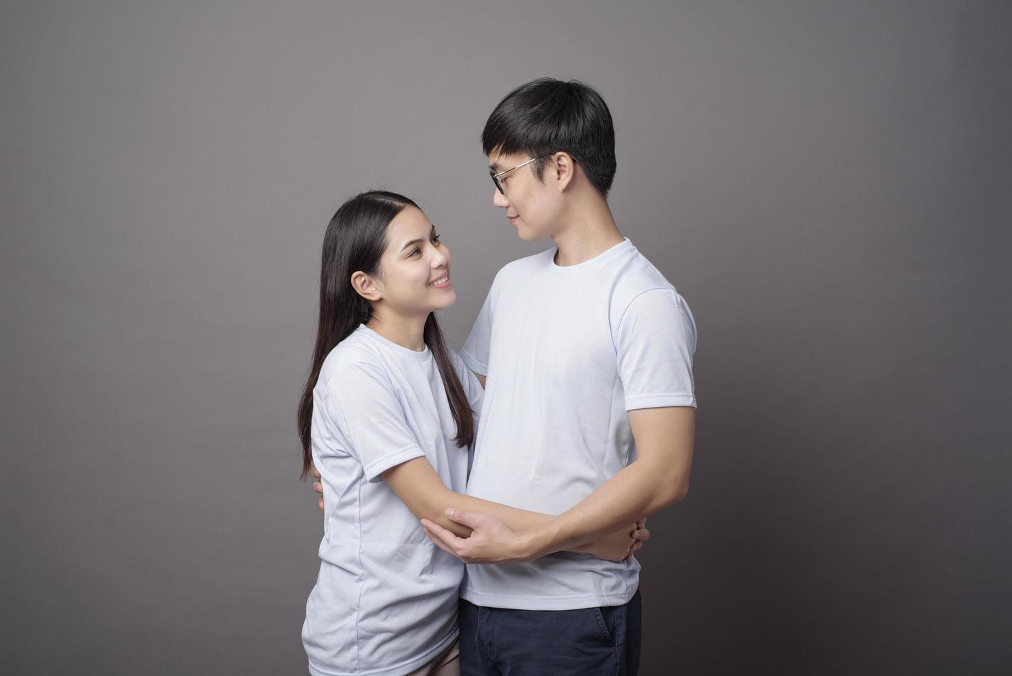 un portriat d'un couple heureux vêtu d'une chemise bleue s'embrasse dans un studio d'arrière-plan gris photo