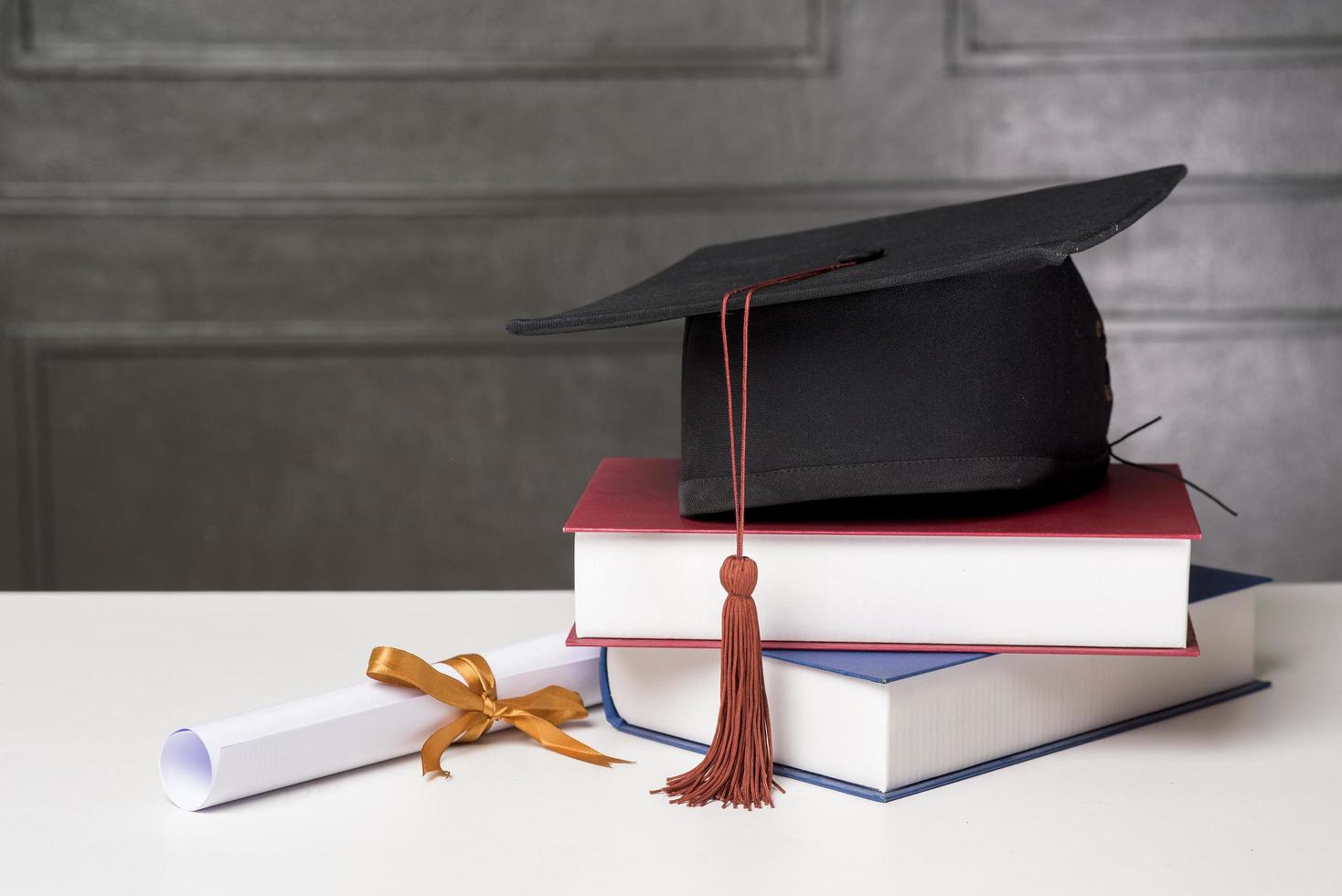 chapeau de graduation avec des livres sur un bureau blanc, fond d'éducation photo