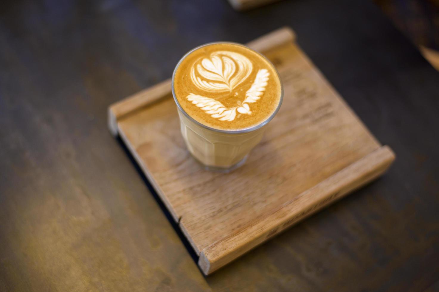 vue de dessus de la tasse d'art latte chaud sur fond de table en bois photo