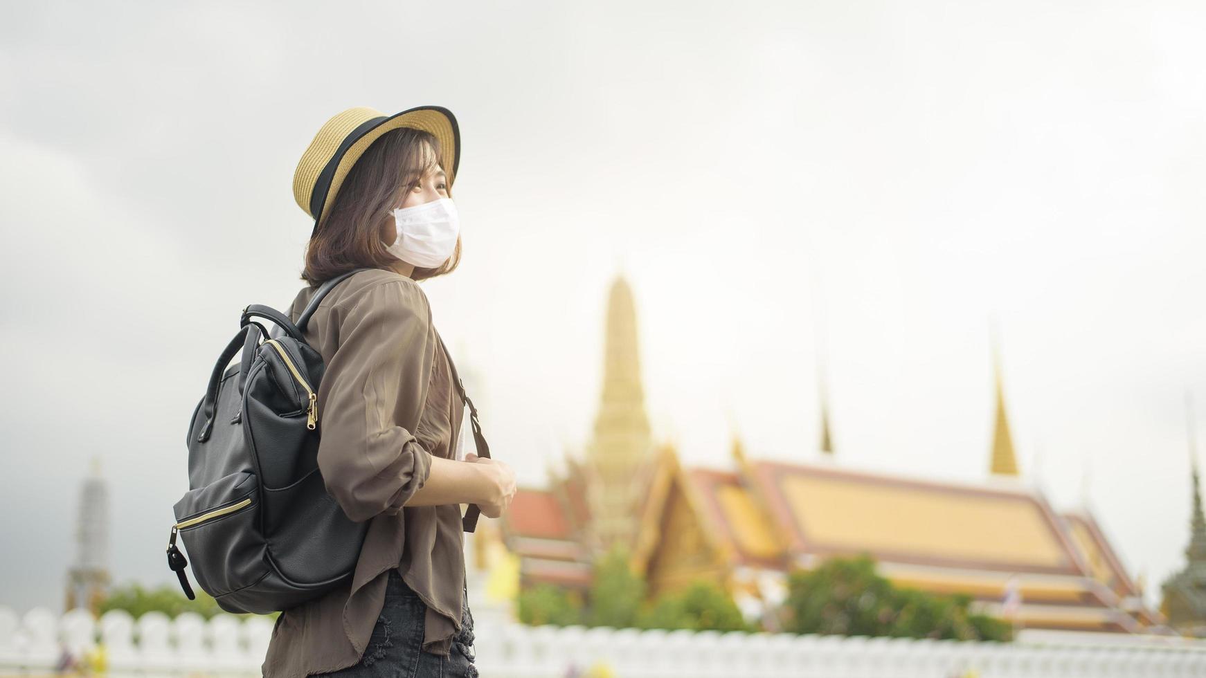 une jeune jolie femme asiatique porte un masque de protection voyageant dans des lieux célèbres de la ville de bangkok, nouveau voyage normal, protection covid-19, voyages en toute sécurité photo