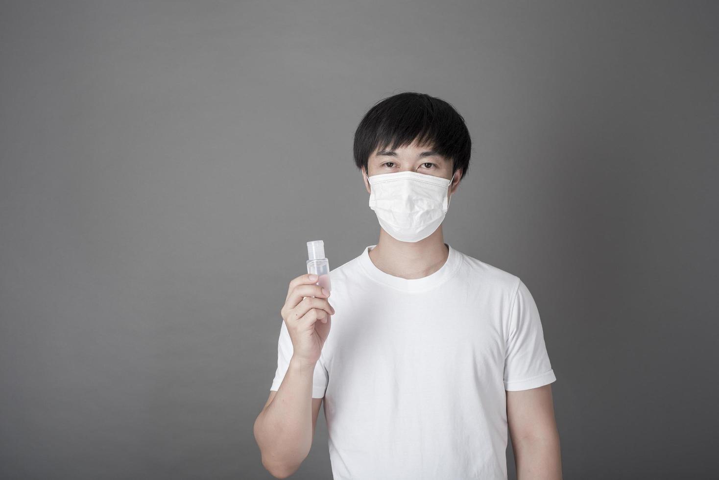 portrait d'homme se désinfectant les mains avec du gel d'alcool, concept de soins de santé photo