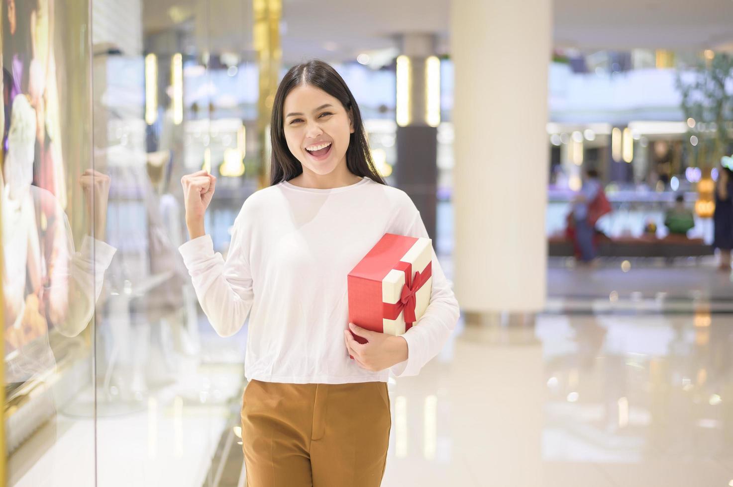femme tenant une boîte-cadeau dans un centre commercial, concept d'action de grâces et de noël. photo