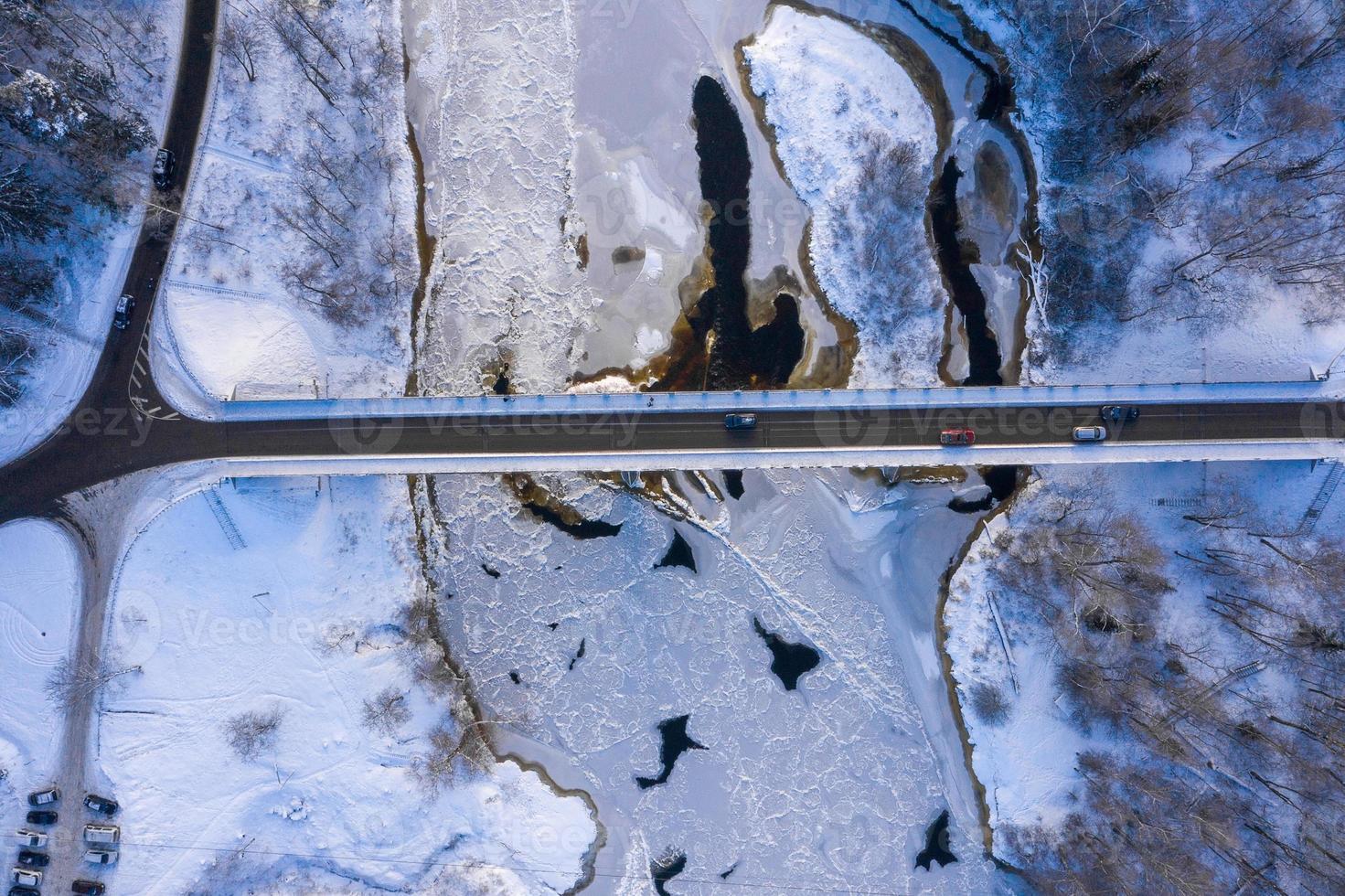 vue aérienne de la rivière et de la forêt enneigée après un blizzard dans une brume matinale. ciel bleu clair. des merveilles d'hiver. Parc national de Gauja, Sigulda, Lettonie photo