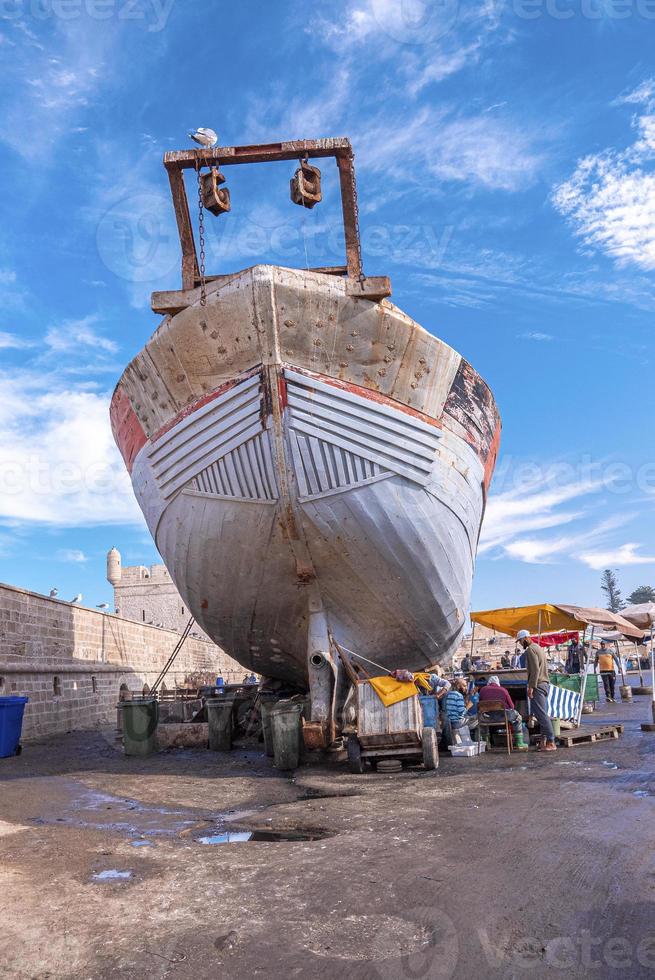 Bateau garé sur la route à côté du mur d'enceinte contre ciel nuageux photo