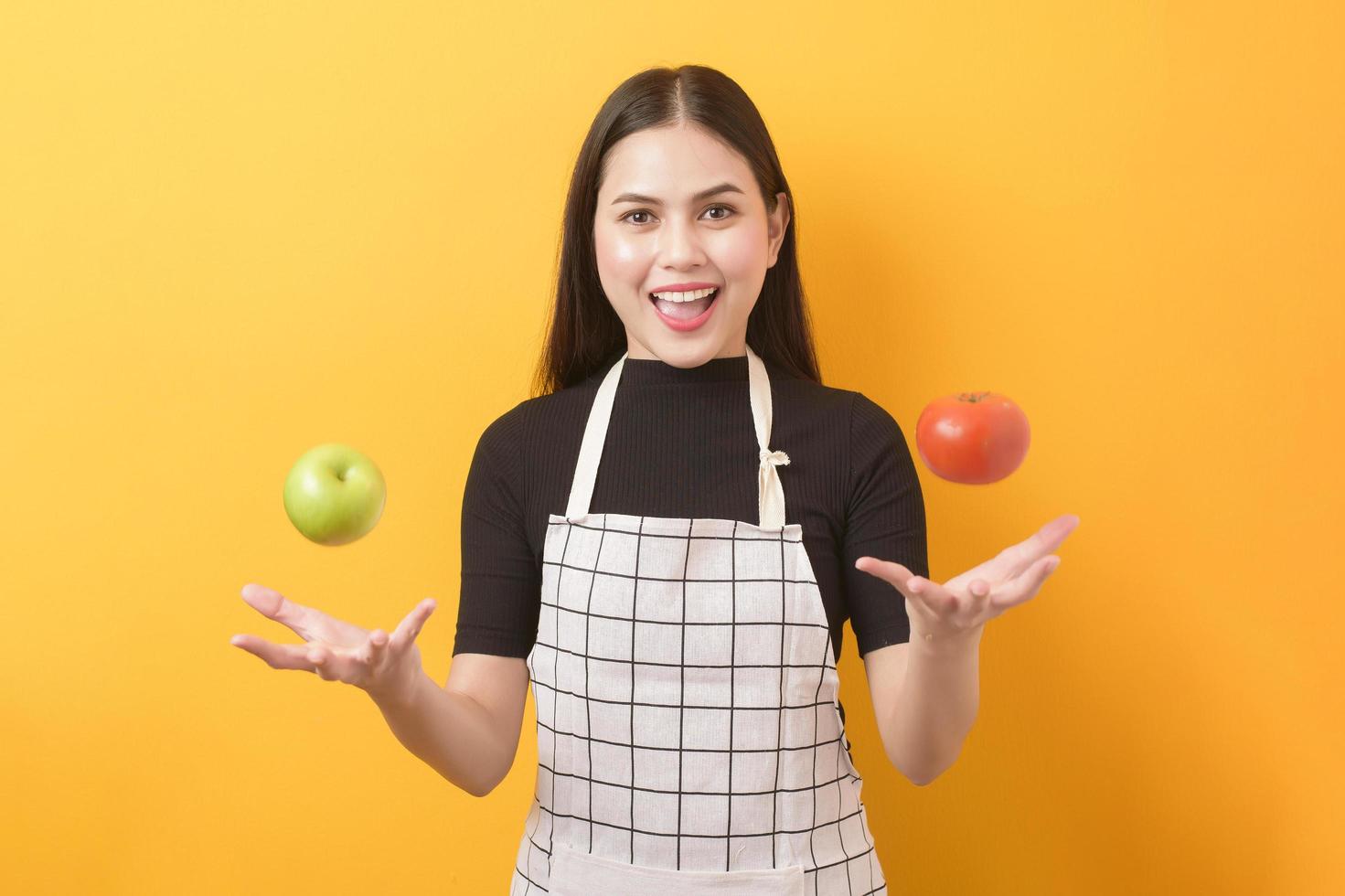 belle femme tient une pomme sur fond jaune photo