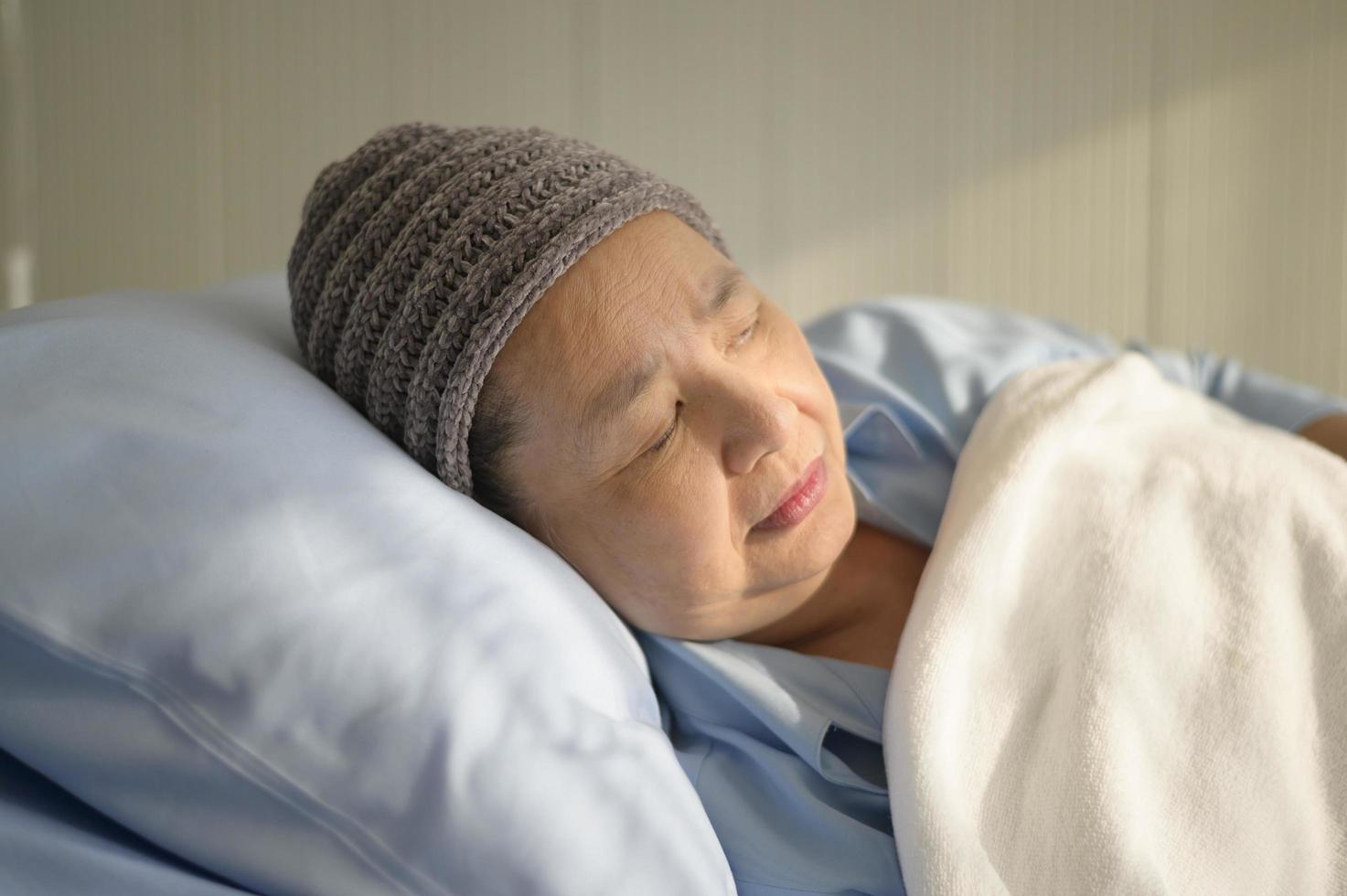 femme asiatique souffrant de cancer déprimée et désespérée portant un foulard à l'hôpital. photo