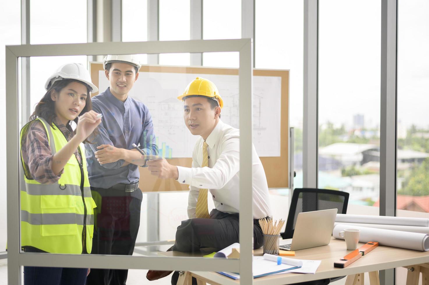 les ingénieurs sont des plans de construction analytiques avec un plan au bureau photo