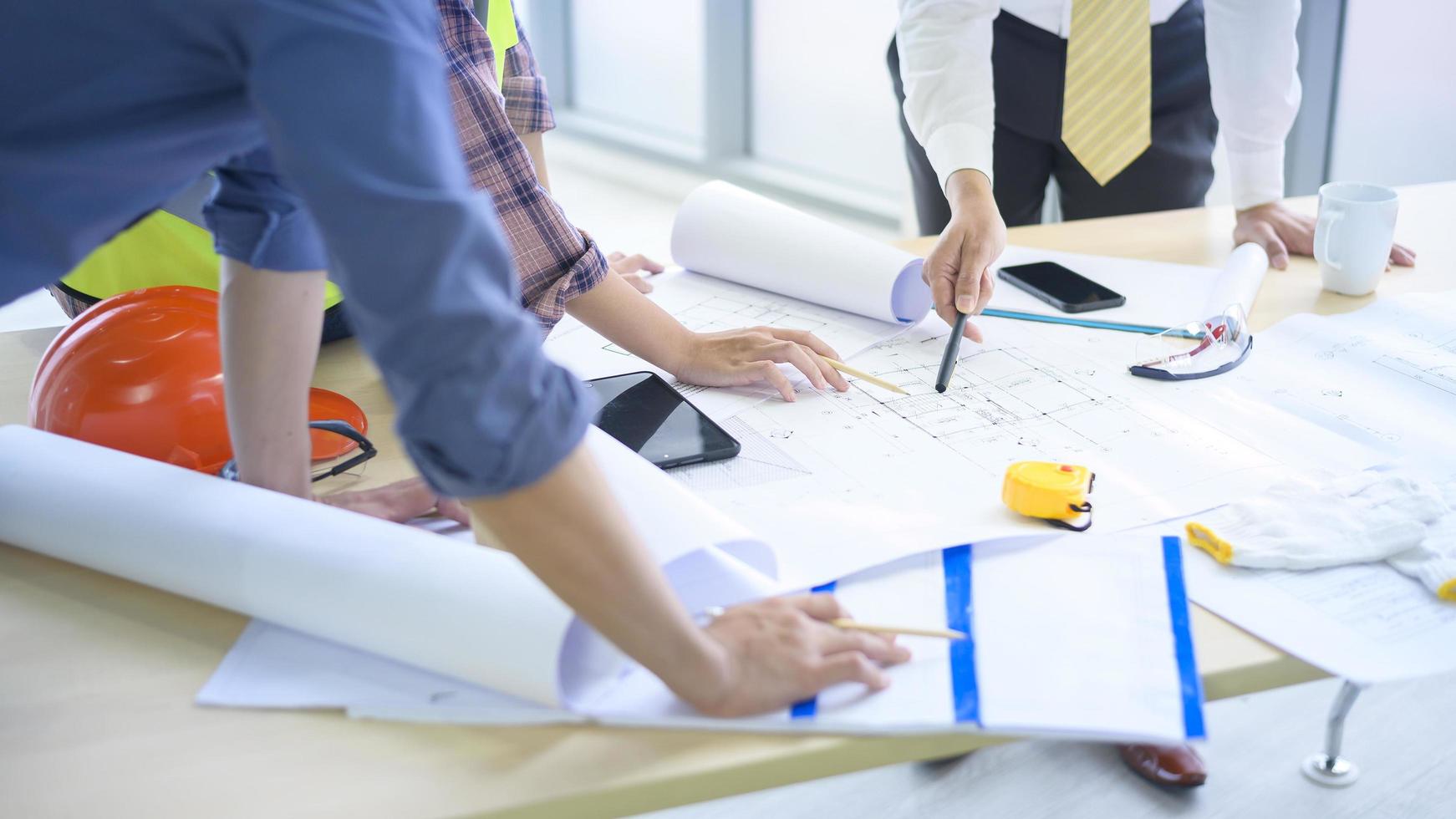 les ingénieurs en gros plan sont des plans de construction analytiques avec un plan au bureau photo