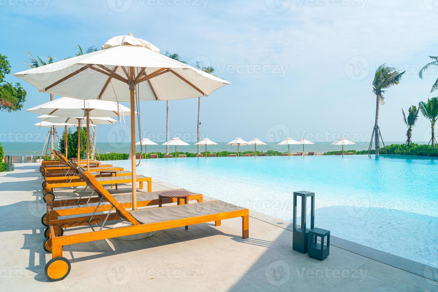 parasol avec lit piscine autour de la piscine avec fond de mer océan photo