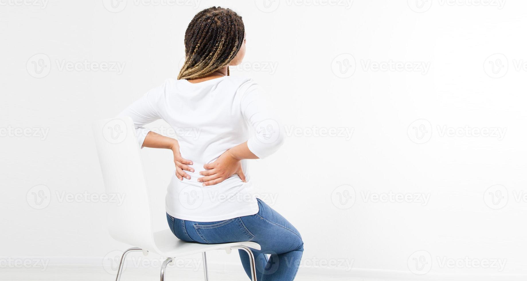 belle femme souffrant de maux de dos sur chaise - vue arrière, espace de copie de rhumatisme féminin photo