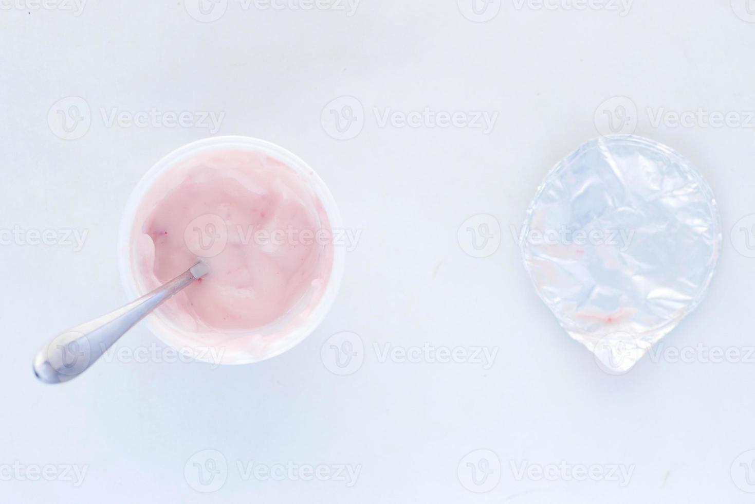 yaourt frais dans un récipient en plastique et cuillère sur table photo