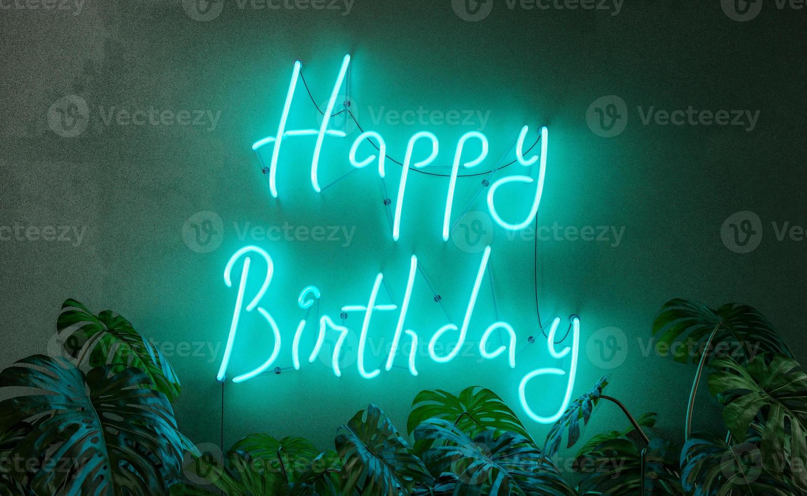joyeux anniversaire enseigne au néon avec des plantes devant photo