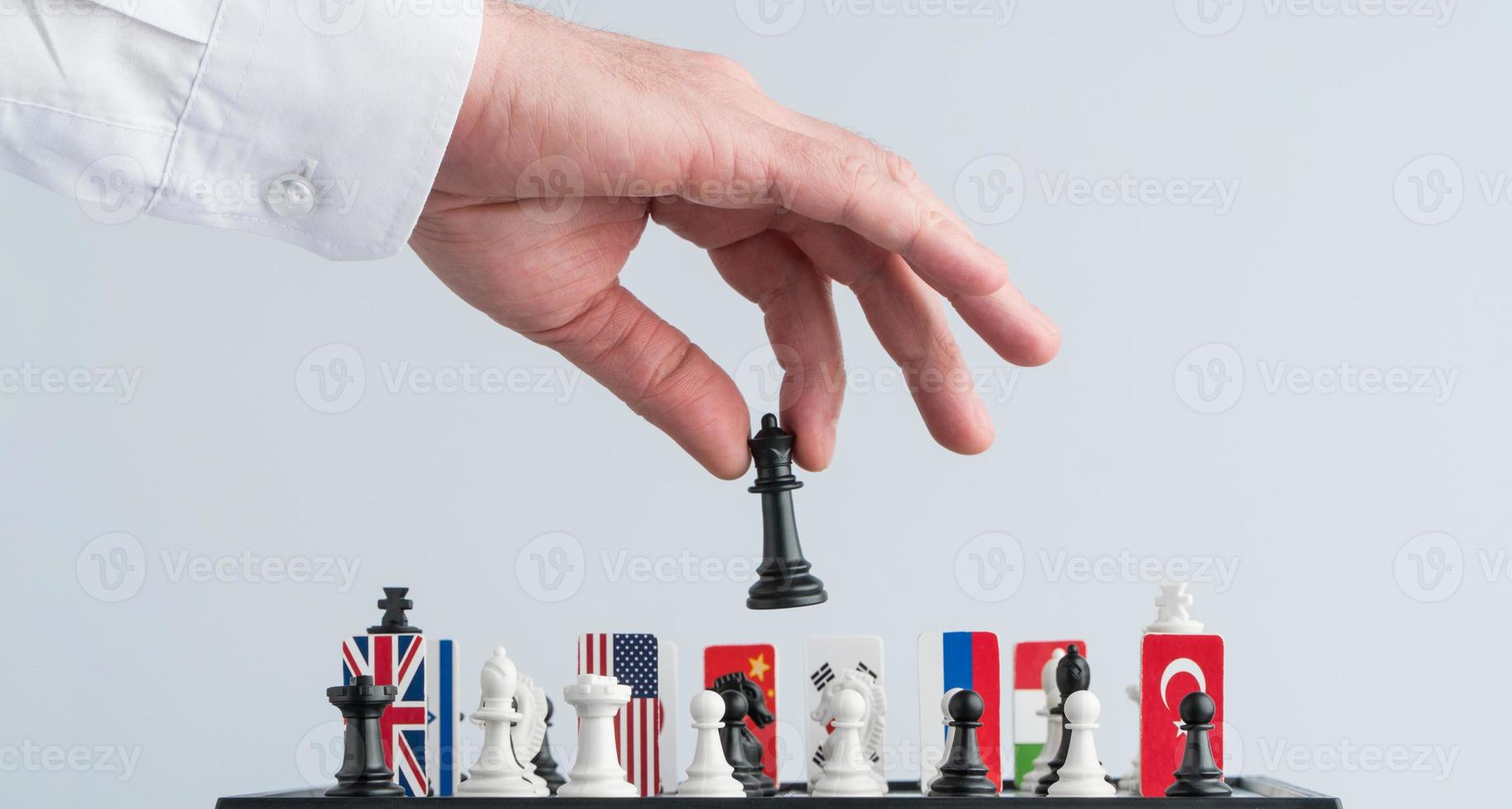 la main du politicien déplace une pièce d'échecs. photo conceptuelle d'un jeu politique et de stratégie.