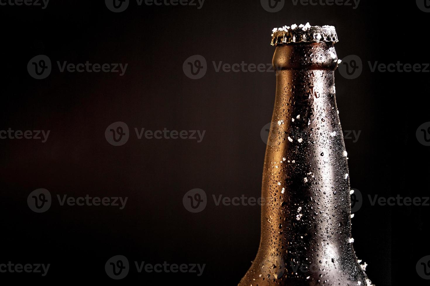 bouteille de bière avec de la glace givrée photo