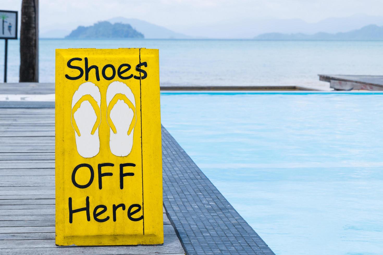 aucun signe de chaussures d'avertissement au bord de la piscine sur le plancher en bois photo