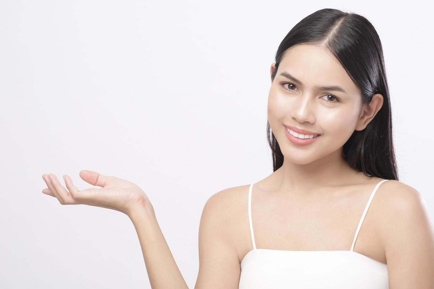 portrait de jeune belle femme avec une peau saine et lisse sur fond blanc, concept de soins de la peau photo