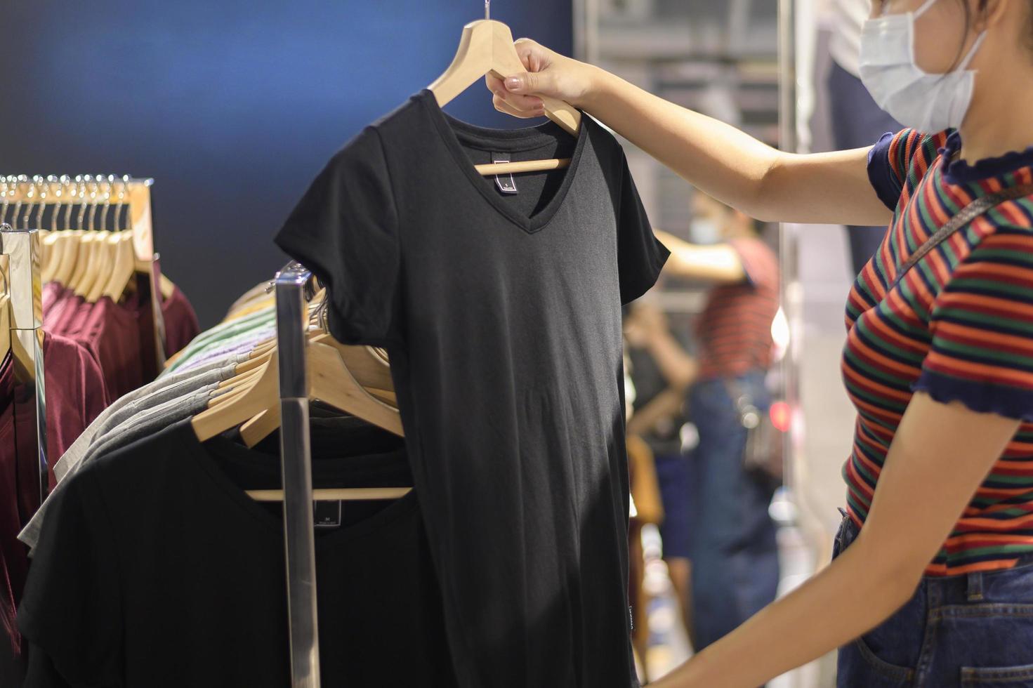 une femme avec un masque facial fait ses courses dans un centre commercial photo