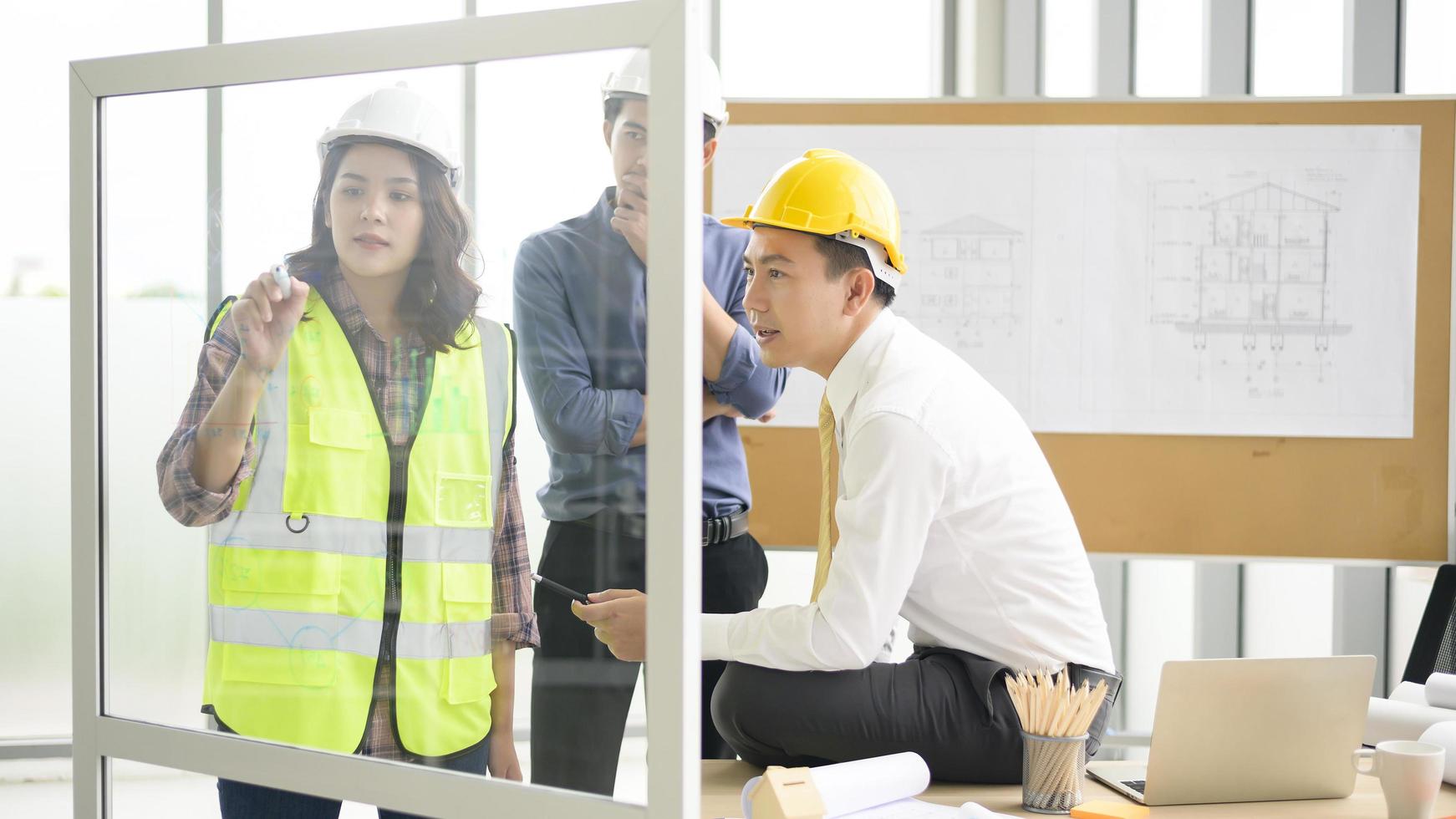 les ingénieurs sont des plans de construction analytiques avec un plan au bureau photo