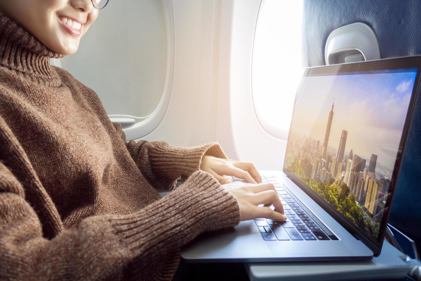 une jeune femme portant un masque facial voyage en avion, nouveau voyage normal après le concept de pandémie de covid-19 photo