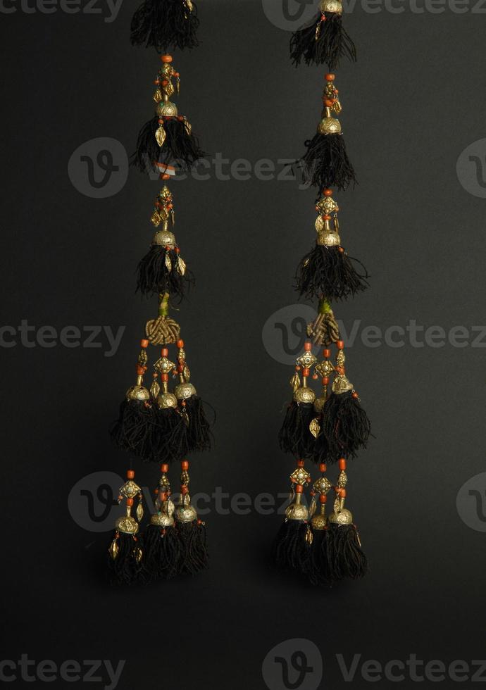 boucles d'oreilles antiques anciennes avec des pierres sur fond noir. bijoux vintage d'asie moyenne photo