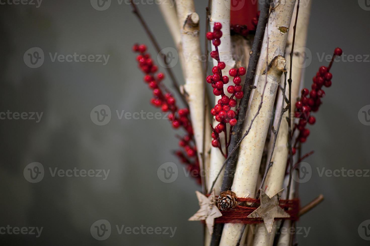 décoration de noël de faisceaux de branches en bois avec des baies et des pommes de sapin photo