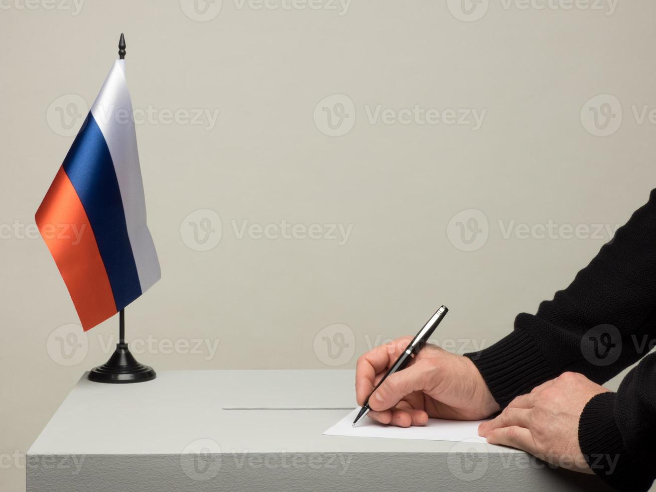 urne avec le drapeau national de la russie. élection présidentielle. main jetant un bulletin de vote photo