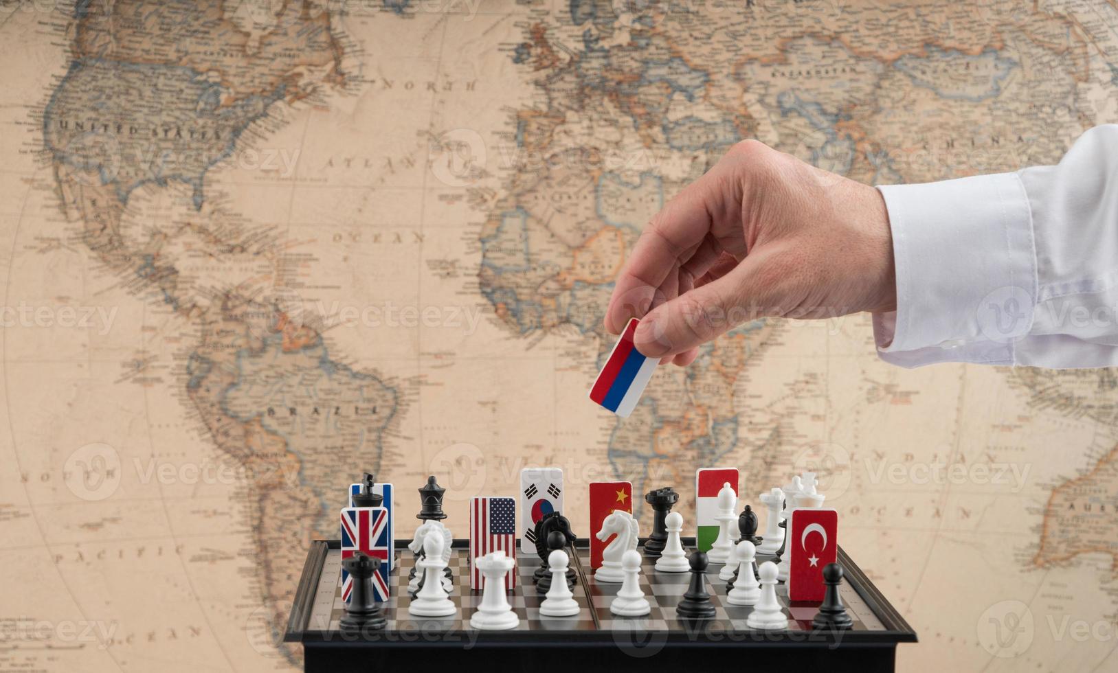 la main du politicien déplace une pièce d'échecs avec un drapeau. photo conceptuelle d'un jeu politique. coup de représailles de la russie
