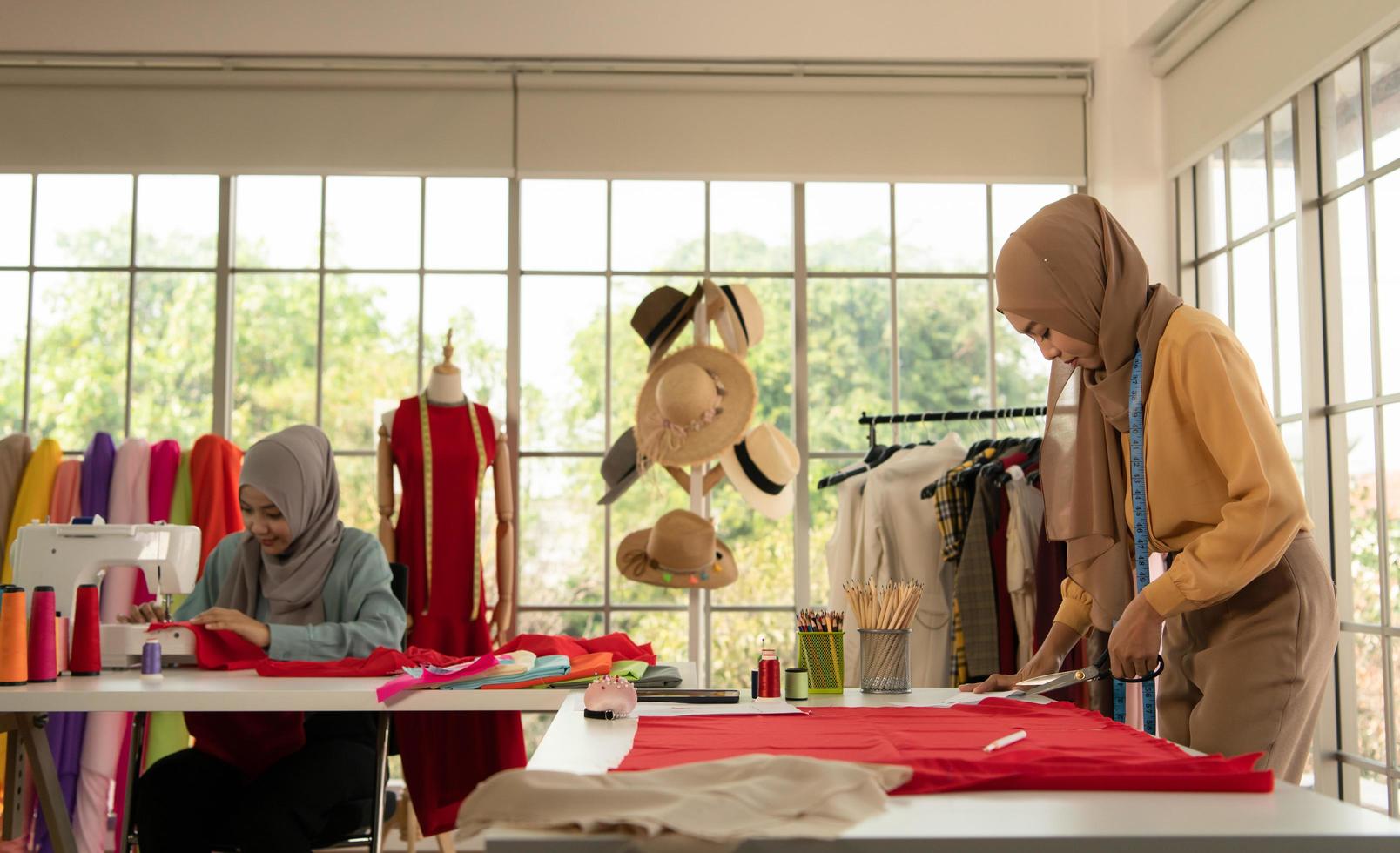 les deux femmes musulmanes dirigent une petite entreprise dans leur propre maison. est la conception et la confection de vêtements. photo