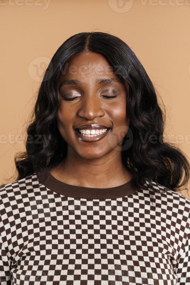 calme femme africaine souriante debout avec les yeux fermés photo