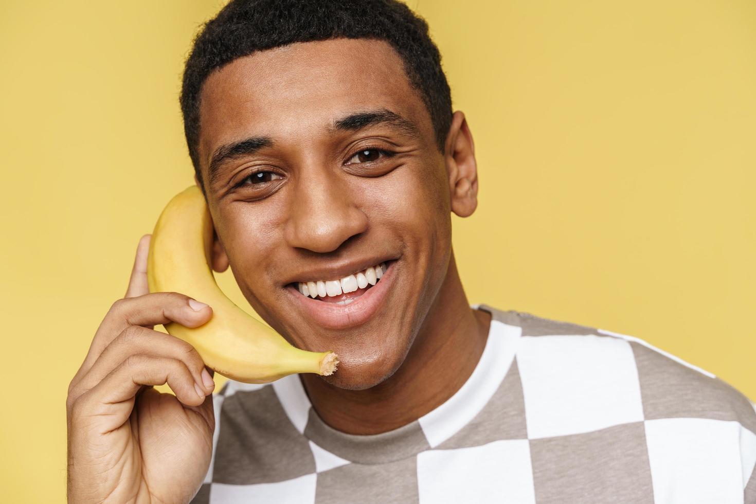 portrait d'un homme africain souriant appelle la banane photo